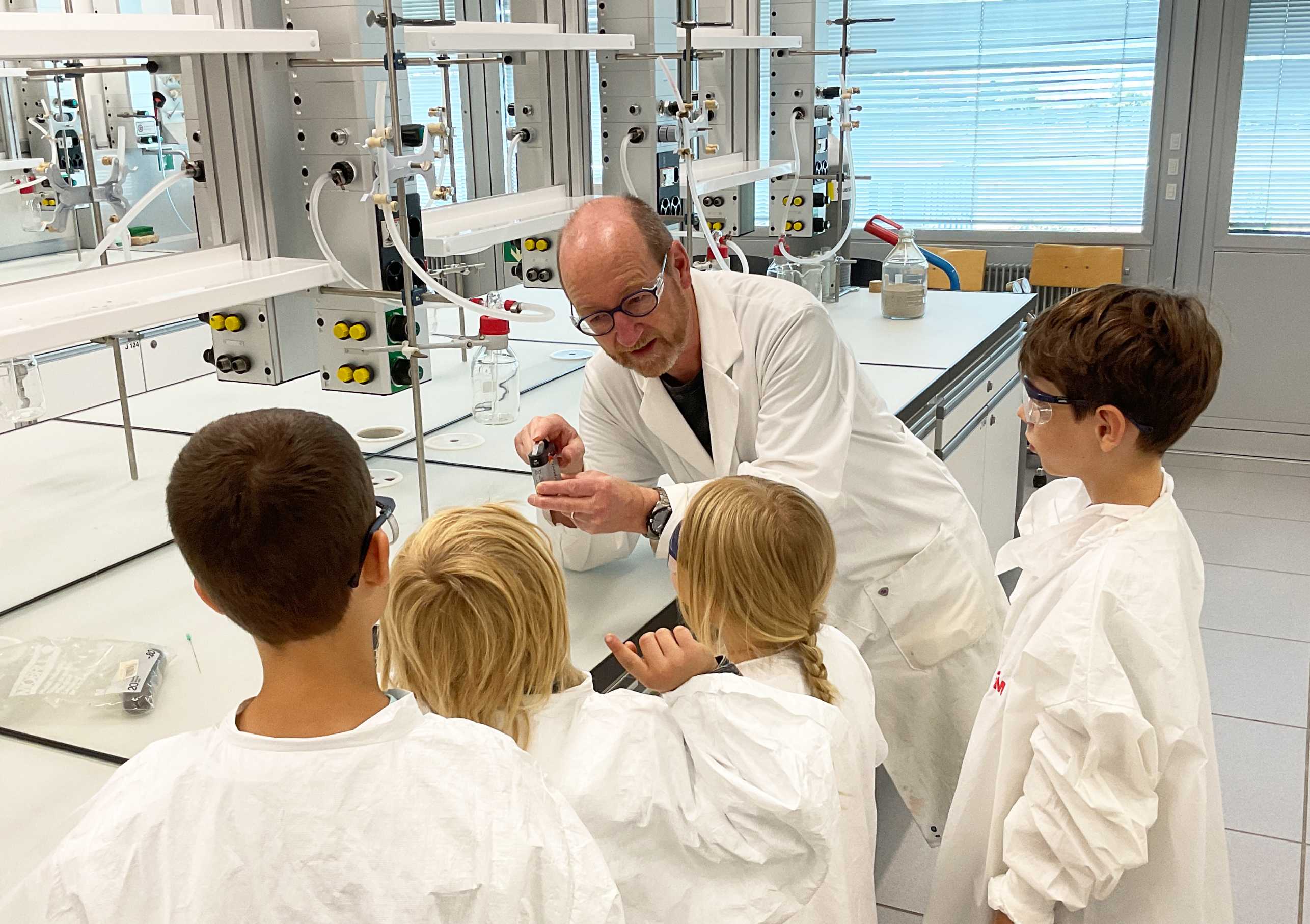 Junge Chemiker:innen lernen mit Erich Meister im Labor mehr über Batterien 